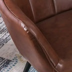 Fauteuil d'appoint en cuir marron foncé avec dossier capitonné et accoudoirs ailés