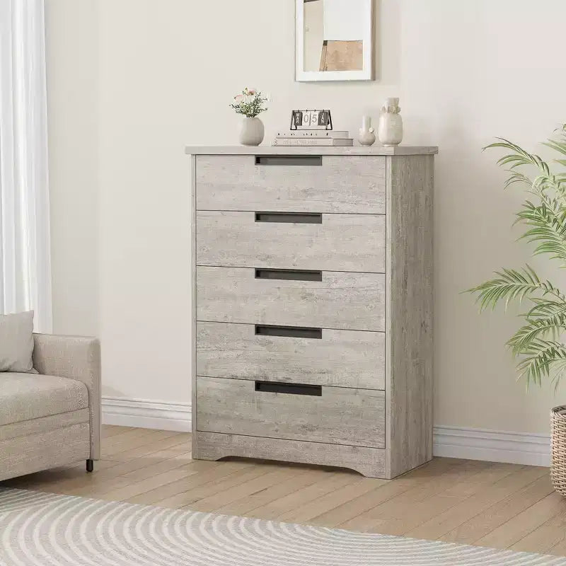Commode cinq tiroirs avec poignées intégrées, meuble de rangement moderne en bois, compact et peu encombrant, adapté aux salons.